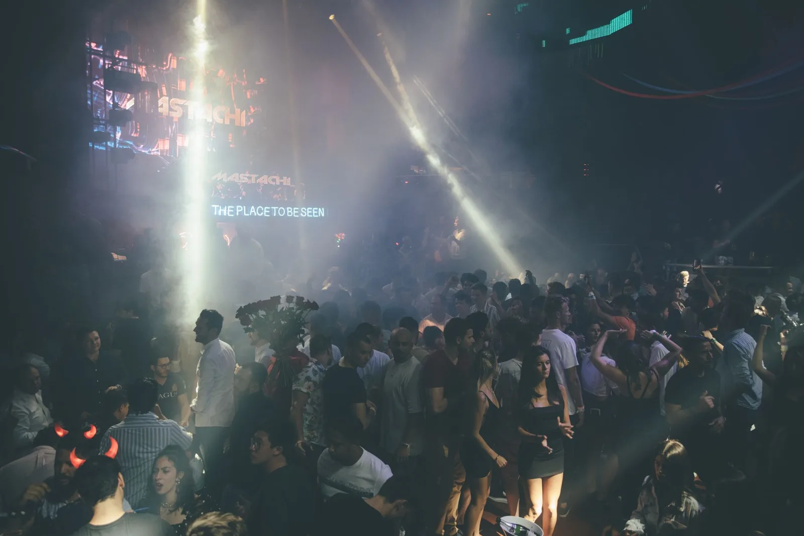 Žurka sa 150+ hitova, gomila ljudi pleše uz muziku i šarene svetlosne efekte