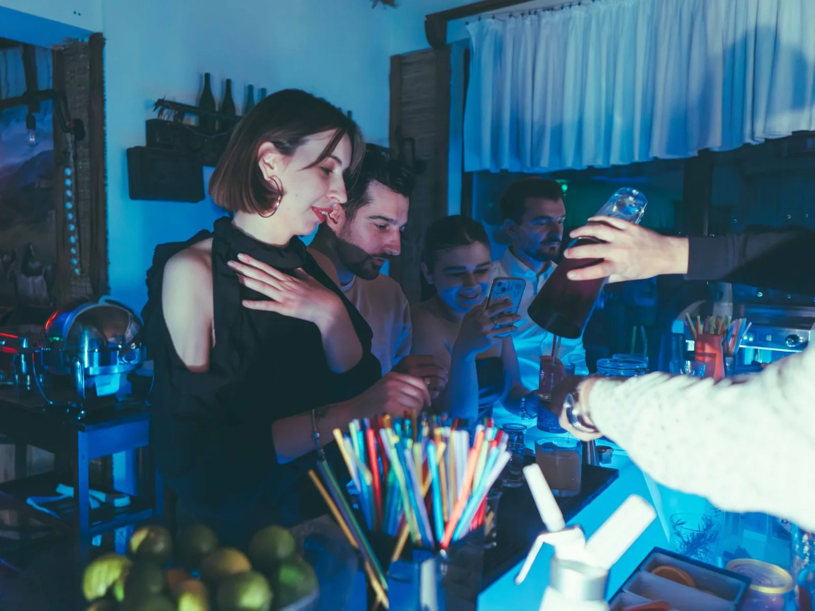 Društvo peva za istim stolom u lounge baru uveče uz pesme Sinana Sakića